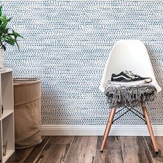 a white chair sitting in front of a wall with a shoe on top of it