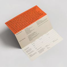 an orange and white brochure with information on the front cover is folded in half