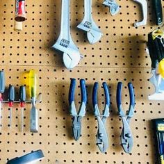 there are many tools hanging on the pegboard