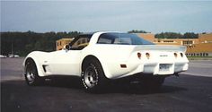 a white sports car parked in a parking lot