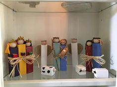 several wooden toys are on display in a glass case and tied with twine bows