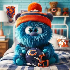 a blue and orange stuffed animal with a football helmet on top of a bed in a bedroom