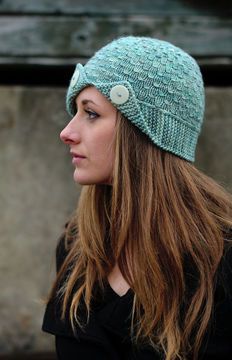 a woman wearing a knitted hat with buttons on the front and back of her head