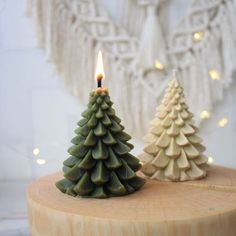 two small christmas trees sitting on top of a wooden table