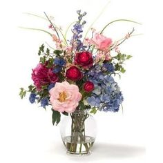 a vase filled with lots of different colored flowers