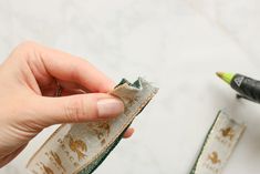 someone is sewing fabric on the edge of a piece of cloth with a green crayon