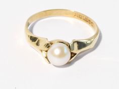 Here is a vintage 9ct gold real Pearl solitaire ring. The Pearl is a lovely creamy white colour and sits between petal shaped shoulders. This is not a faux pretend Pearl it is a real pearl and probably cultured. It is hallmarked to the inner shank for Birmingham England 9ct gold 375 1965 and the makers mark is C.P.S. It is a UK size q. 1/2 and a US size 8. 1/2. The Pearl measures approx 5.75mm in diameter. The height of the whole mount from the finger to the top of the Pearl measures 6mm. It wei Classic Hallmarked Pearl Ring, Vintage White Pearl Ring, Birmingham England, Real Pearls, Lovely Ring, White Colour, Ring Vintage