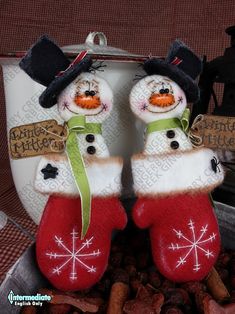 two snowmen in red stockings and black hats are sitting next to some dog treats