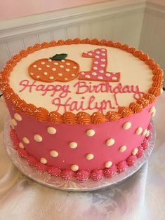 a pink and white birthday cake with polka dots