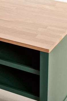 a close up of a wooden table with two shelves on one side and an open shelf on the other