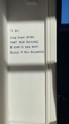 a white wall with writing on it next to a window