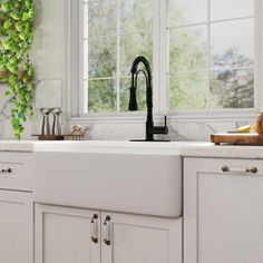 a white kitchen sink sitting under a window