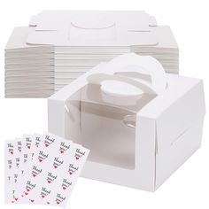 a white box filled with lots of stickers next to a stack of folded boxes