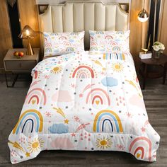 a bed with rainbows, clouds and stars on the sheets is shown in this room