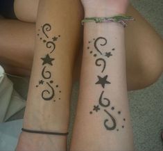 two girls with matching tattoos on their arms, one has stars and the other has swirls