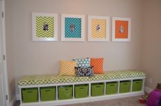 a child's room with three pictures on the wall and four green bins