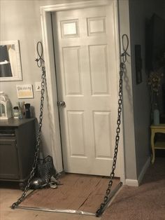 the door is open and there is a swing in front of it that has chains on it