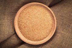 a wooden bowl filled with oatmeal sitting on top of a brown cloth