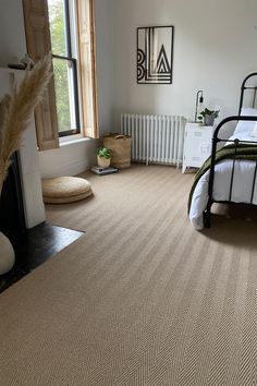 a bed room with a neatly made bed next to a window and a radiator