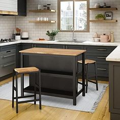 a kitchen with two stools in front of the island