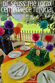 the table is set with plates and napkins for an event or party that has colorful decorations on it