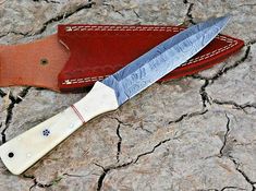 a knife sitting on top of a red leather case