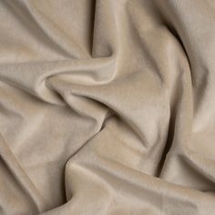 a close up view of a plain beige fabric with very soft folds and wrinkles