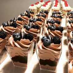 there are many cupcakes with chocolate frosting and berries on top