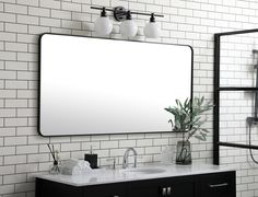 a bathroom vanity with a large mirror and two faucets on the wall next to it