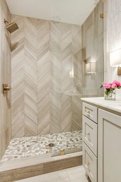 a bathroom with a walk in shower next to a white sink and counter top under a mirror