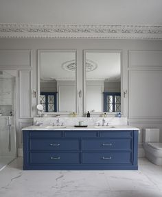 a bathroom with two sinks and three mirrors