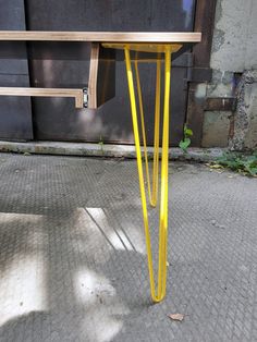 a yellow table sitting on top of a sidewalk