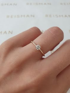 a woman's hand with a diamond ring on it