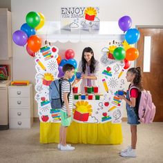 two girls and a girl standing in front of a table with legos on it