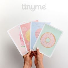 a person holding five cards with doughnuts on them in front of a white background