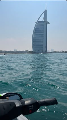 the burj building in the middle of the water is very tall and can be seen