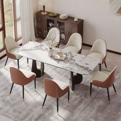 a dining room table with chairs and a vase on the top, in front of a large window