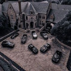 an aerial view of a mansion with many cars parked in front