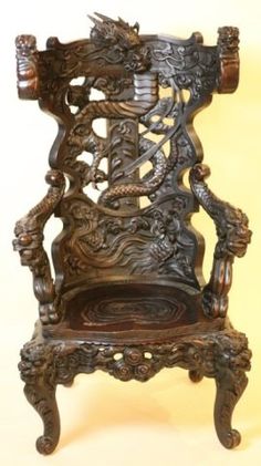 an ornate wooden chair sitting on top of a table