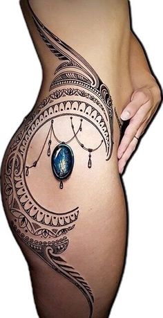 a woman's stomach with an intricate tattoo design on the side, and a blue stone hanging from it