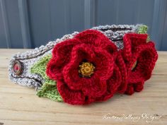 two crocheted flower headbands sitting on top of a wooden table