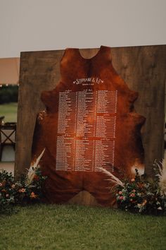 a large wooden sign sitting on top of a lush green field