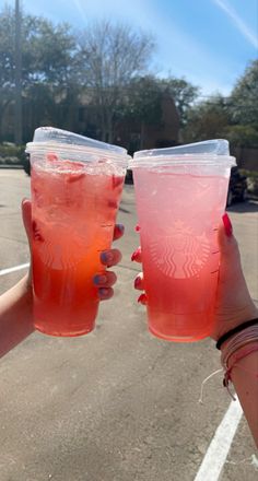 two people holding up drinks in their hands