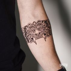 a man's arm with a tattoo on it that looks like an ornate mask