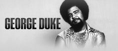 a man with a beard standing in front of a sign that says, george duke