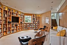 a living room filled with lots of furniture and bookshelves full of bookcases