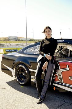 a woman sitting on the back of a race car