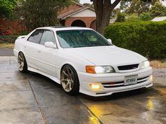 a white car parked in front of a house