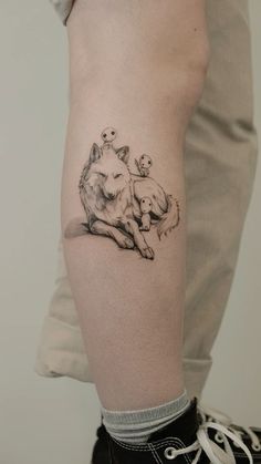 a woman's arm with a tattoo on it that has an image of a dog and two puppies