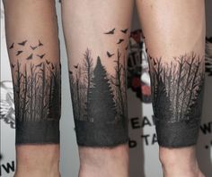 two people with tattoos on their legs and trees in the background, both have birds flying over them